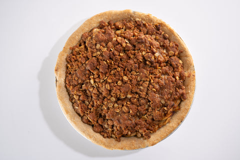 Overhead view of a vegan and gluten-free apple crumb pie with a golden brown oat topping in a rustic crust.