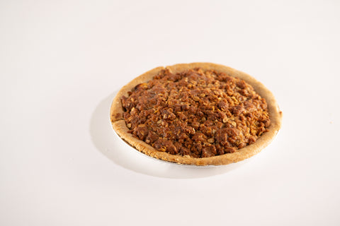 Side view of a vegan and gluten-free apple crumb pie with a golden brown oat topping in a rustic crust.