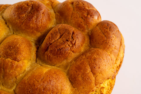 Close-up of gluten-free challah bread loaf, showing detail of the textured crust.
