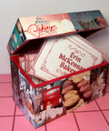 Collaged EMB recipe box with lace details on a pink tile floor 