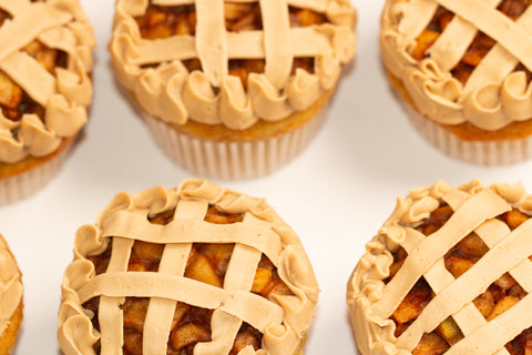 Detailed top view of vegan apple pie cupcakes showing the intricate lattice frosting design and cinnamon-spiced apple filling visible through the decorative pattern