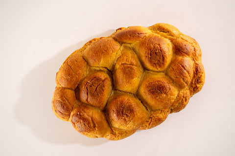Overhead view of golden-brown vegan and gluten-free challah bread loaf.
