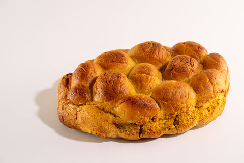 Side angle of gluten-free challah bread showing golden crust and texture.