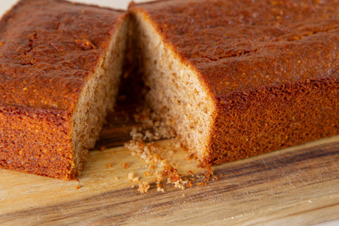 Close-up of sliced vegan gluten-free cornbread from Erin McKenna's Bakery showing golden-brown crust and tender crumb texture on wooden cutting board