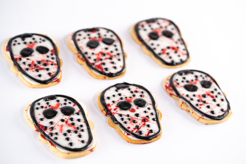 Halloween mask sugar cookies with black, white, and red icing, inspired by slasher movie characters.