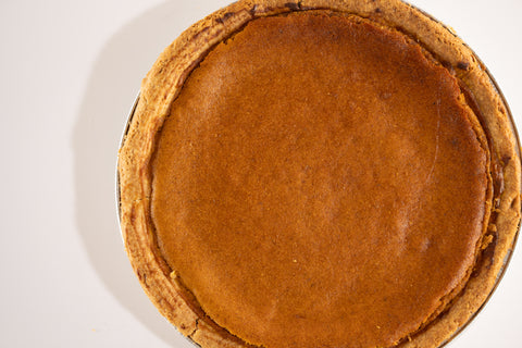 Close-up of a vegan pumpkin pie with a golden, spiced filling in a gluten-free crust.