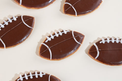 Football-shaped vegan sugar cookies with chocolate icing and white laces decoration