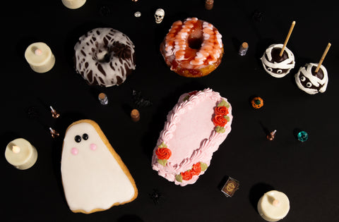 Halloween-themed cookies and cakes on a black background