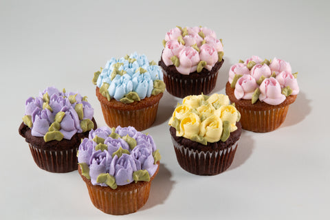Decorative cupcakes with floral designs on a light gray background