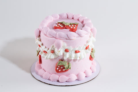 Pink cake with strawberry decorations on a white background
