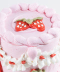 Pink cake with strawberry decorations on a white background