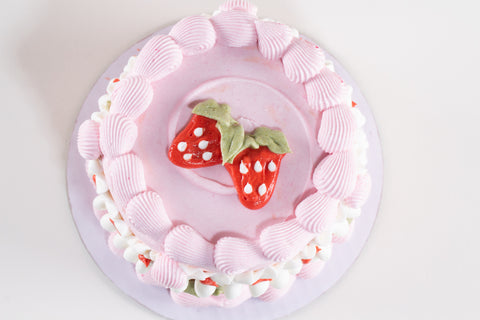 Pink cake with strawberry decorations on a white background