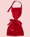 Zoomed out view of a shiny red apron featuring the embroidered initials 'EMB NYC' on the front.